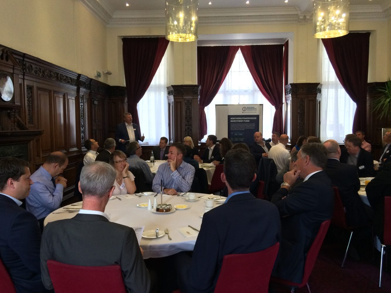 Group of executives at a luncheon function sitting around round tables.