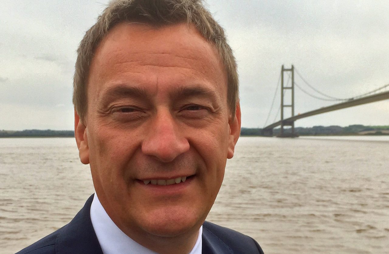 Headshot of man with backdrop of sea and the Humber Bridge.