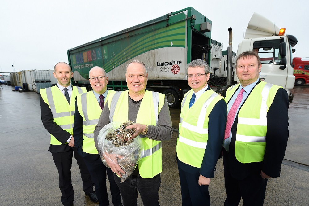 Five men in Hi Vis standing outside in front of a green large truck.