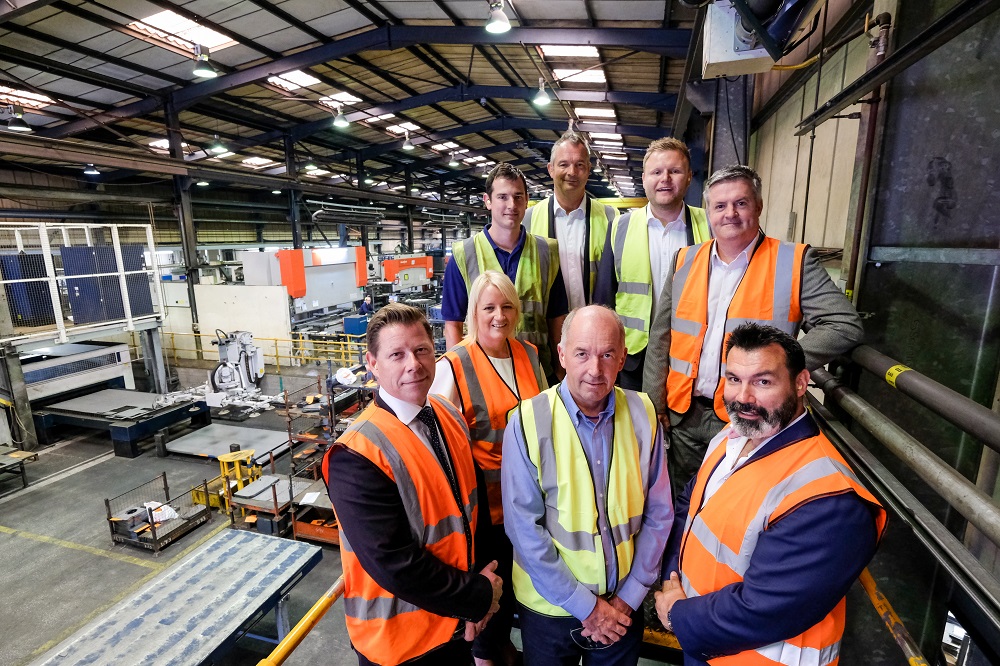 Seven men and one woman wearing Hi Vis in a factory.