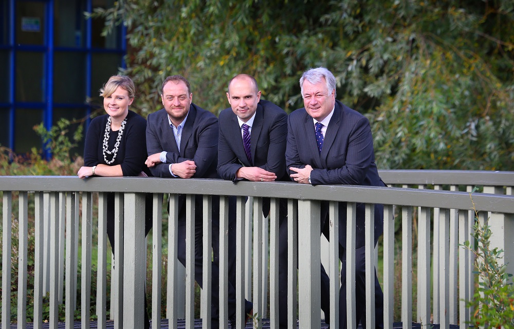 3 men and a woman from Cenergist stood on a bridge outside an office building