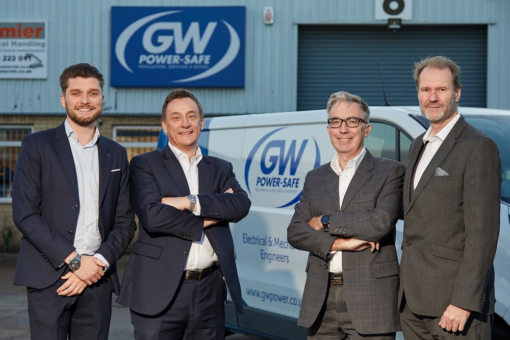 Four men outside GW Power Safe building. They are standing near a branded van.