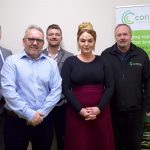 3 men and a woman stood in a meeting room