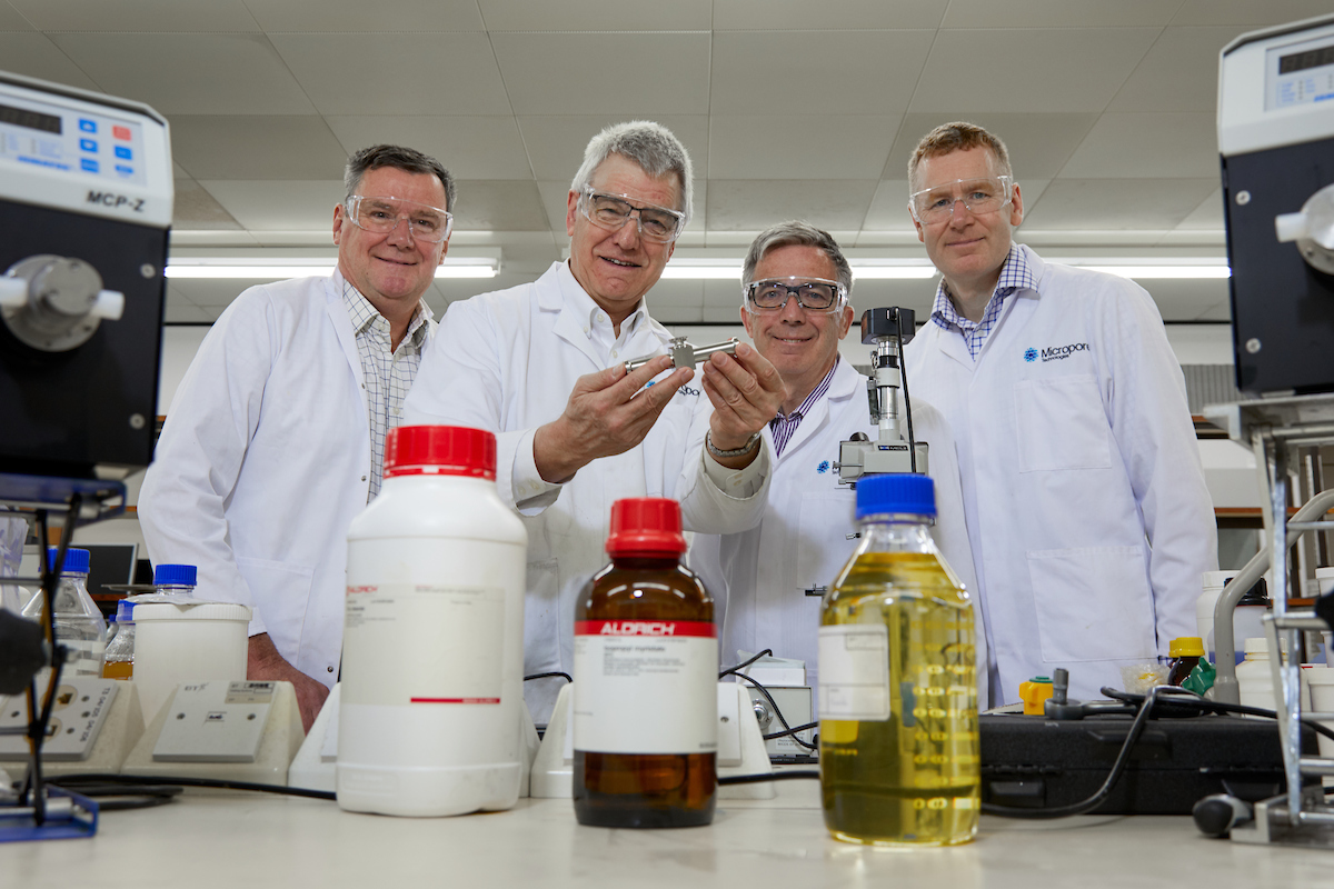 Four men wearing laboratory coats.