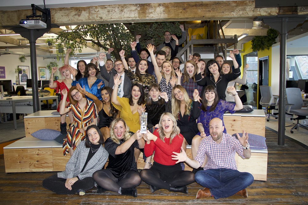 A big group of employees from Buffalo7 celebrating an award in their office