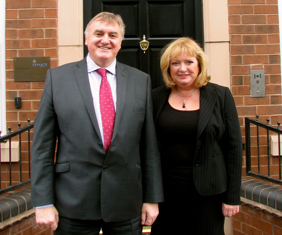 A man and woman stood outside of the Senate House door