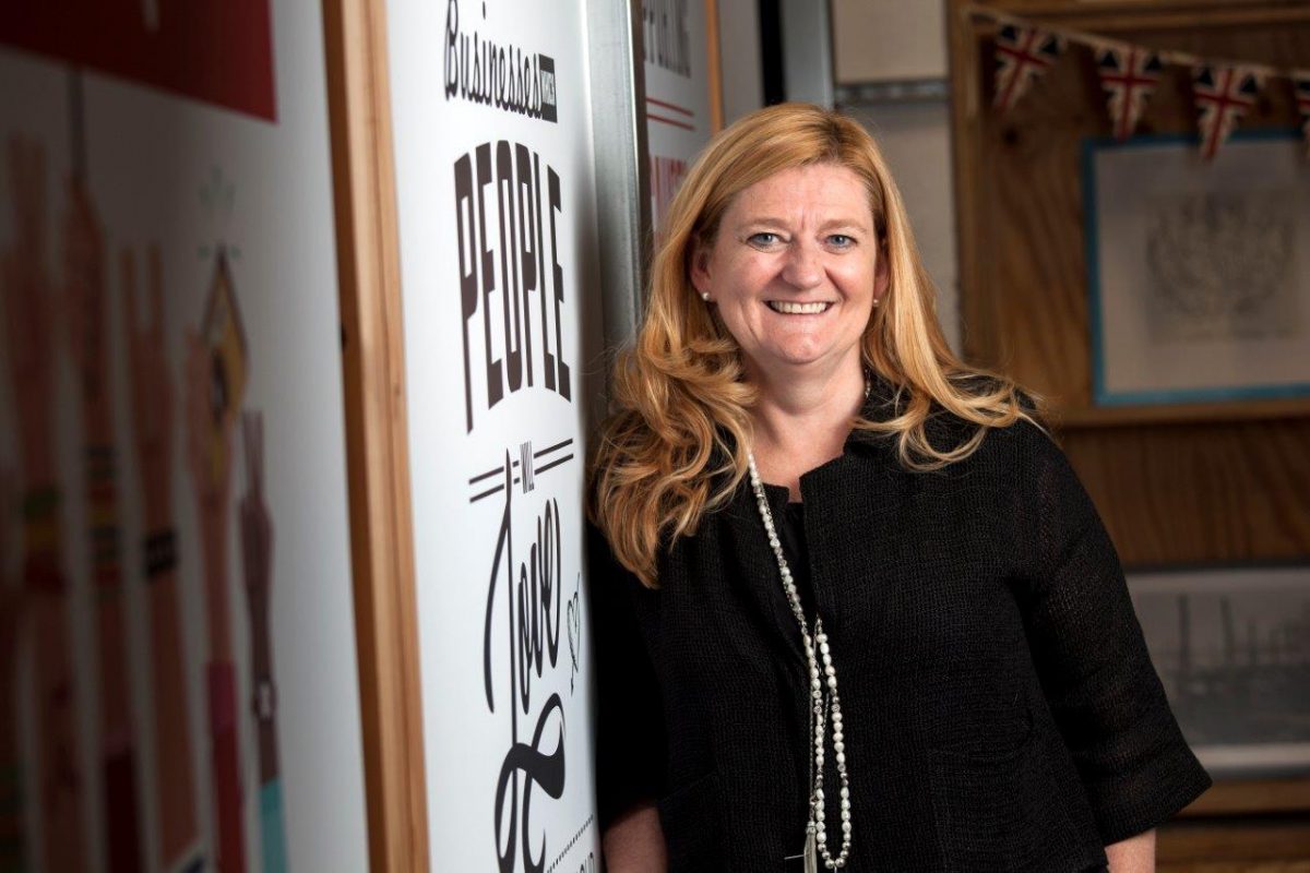 Lorna Davidson, the founder of Redwigwam leaning against a wall smiling