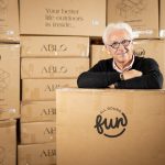 A man standing in front of All Round Fun boxes