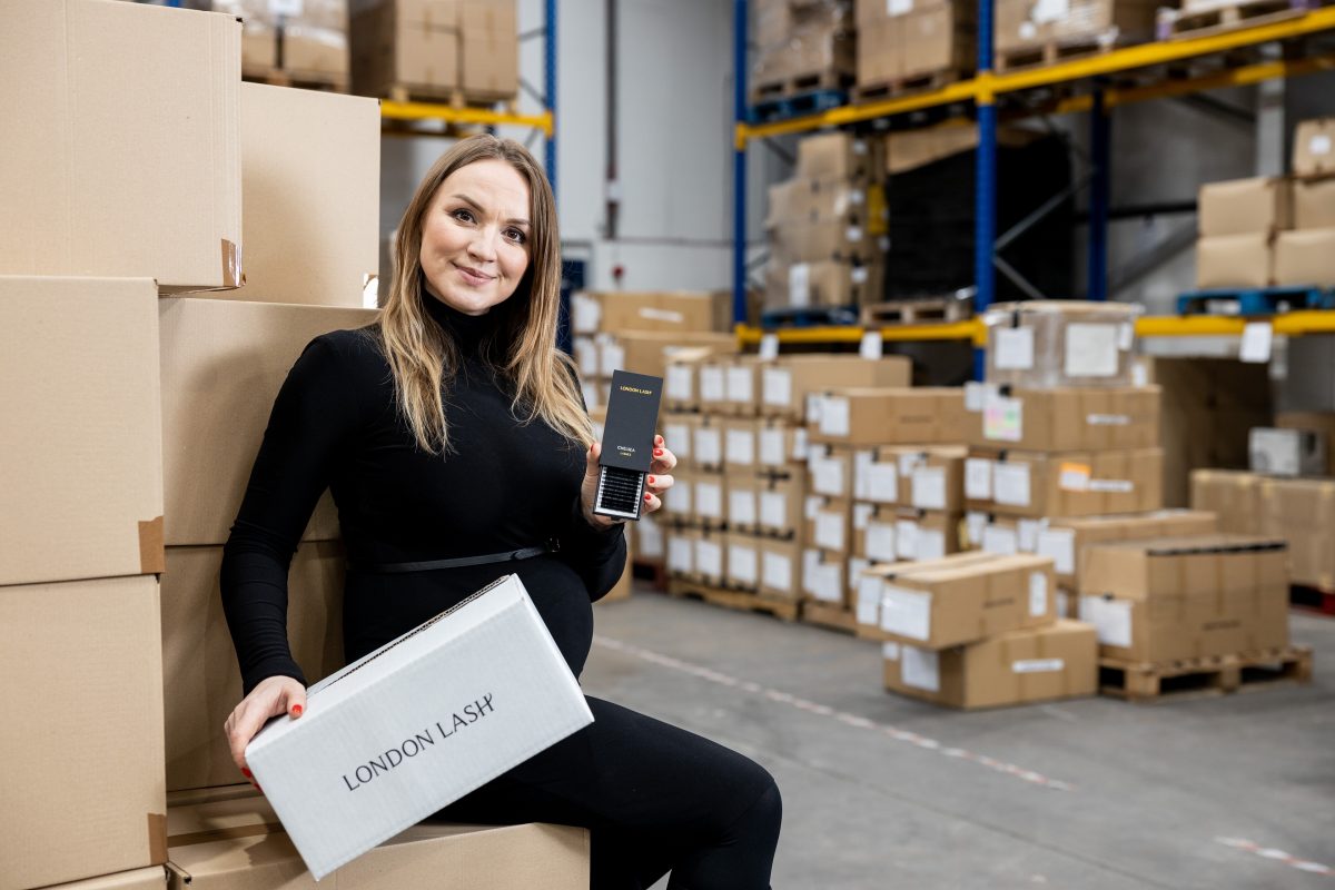 Woman from London Lash sat on a box showing her lash products